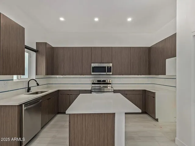a kitchen with stainless steel appliances a sink stove and cabinets