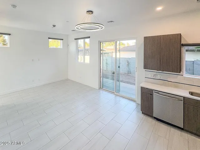 a view of an empty room with window and cabinet