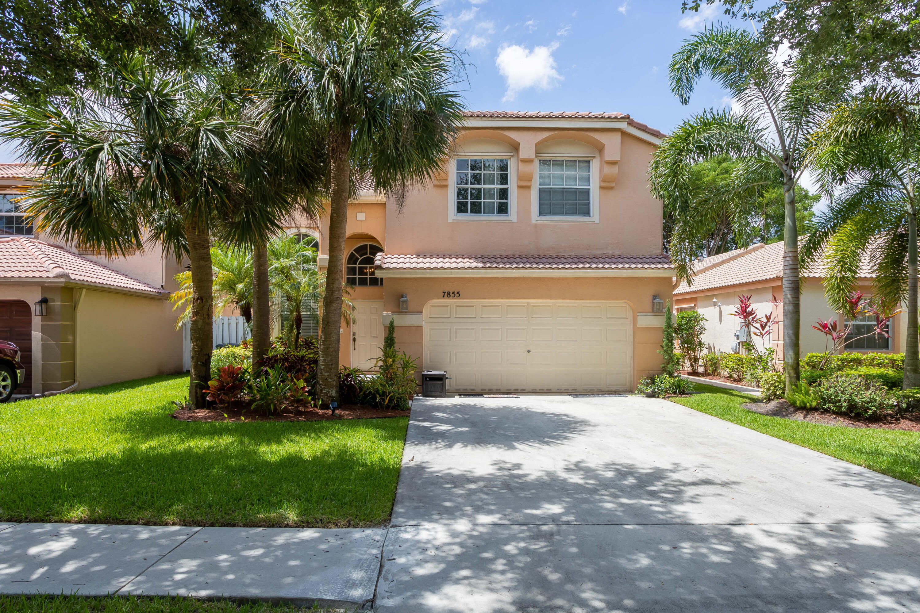 7855 Oak Grove Circle Lake Worth, FL 33467 - Photo 2 of 40 a front view of a house with a yard and garage