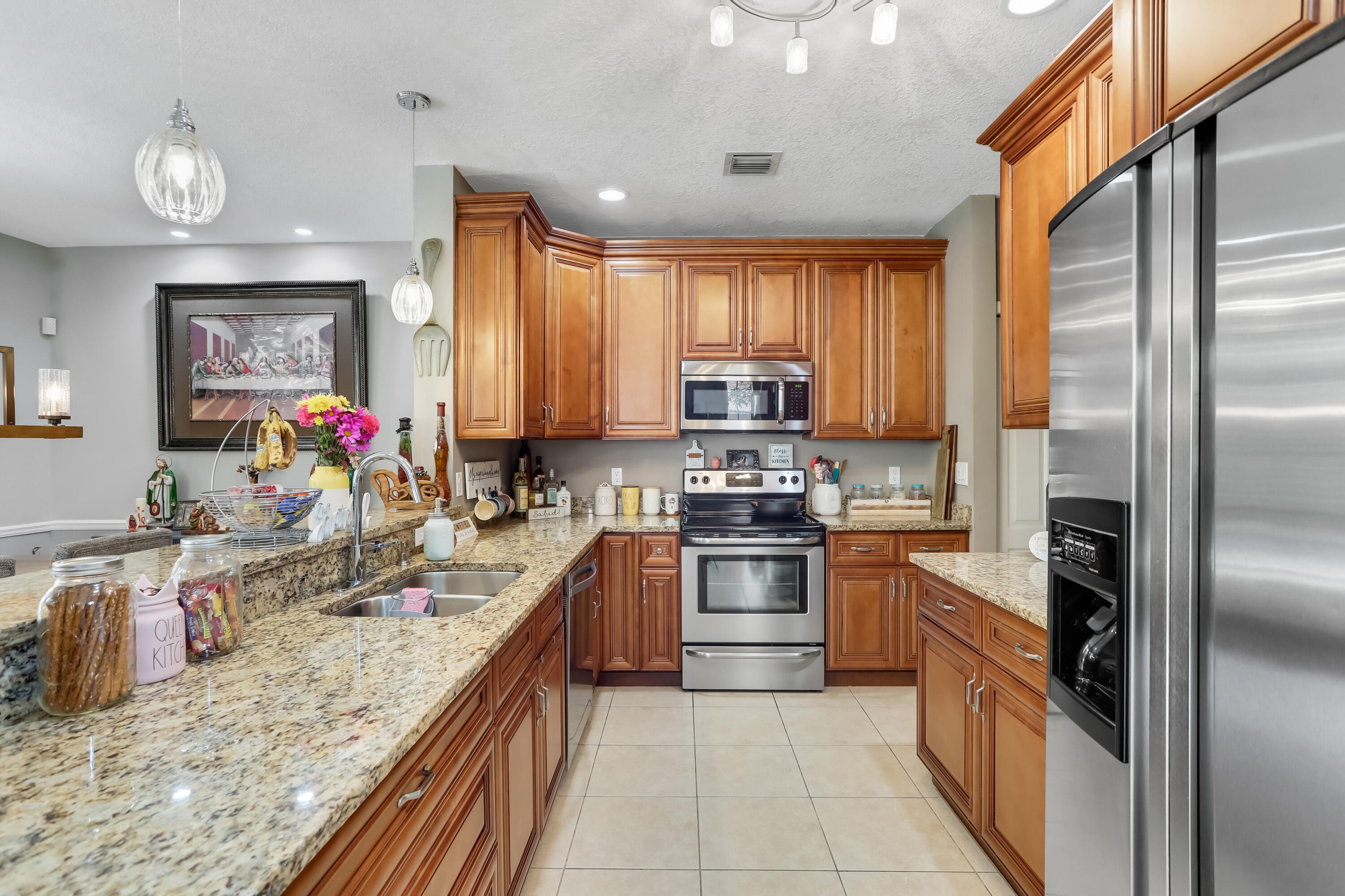 7855 Oak Grove Circle Lake Worth, FL 33467 - Photo 10 of 40 a large kitchen with stainless steel appliances granite countertop a stove refrigerator and a sink