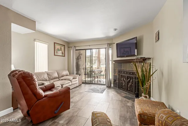 a living room with furniture a fireplace and a flat screen tv