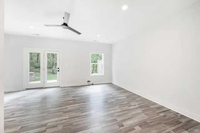 a kitchen with stainless steel appliances a stove top oven a sink a refrigerator white cabinets and wooden floor