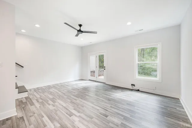 a view of a hallway with stairs and wooden floor