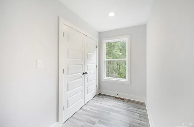 a view of a hallway with wooden floor and a ceiling fan