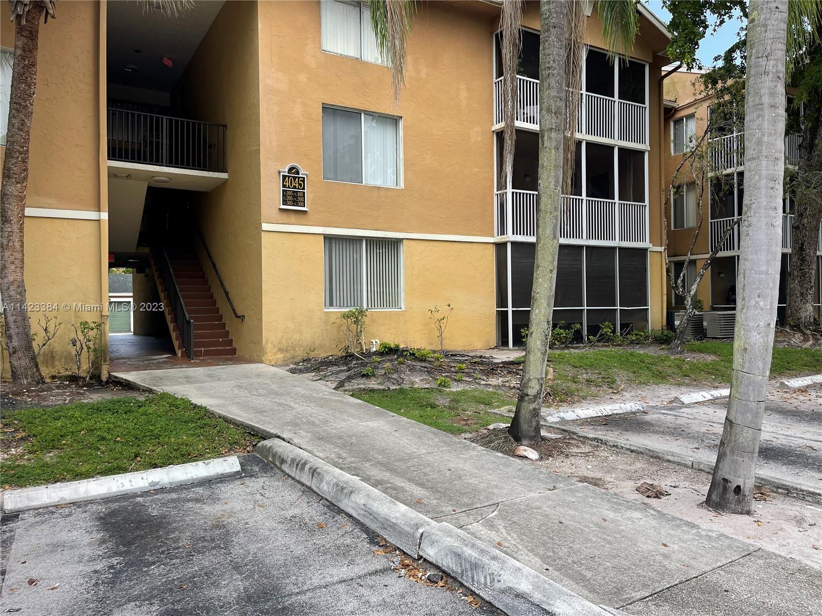 4045 West McNab Road, Unit G106 Pompano Beach, FL 33069 - Photo 20 of 23 a view of a brick house with a yard and large windows