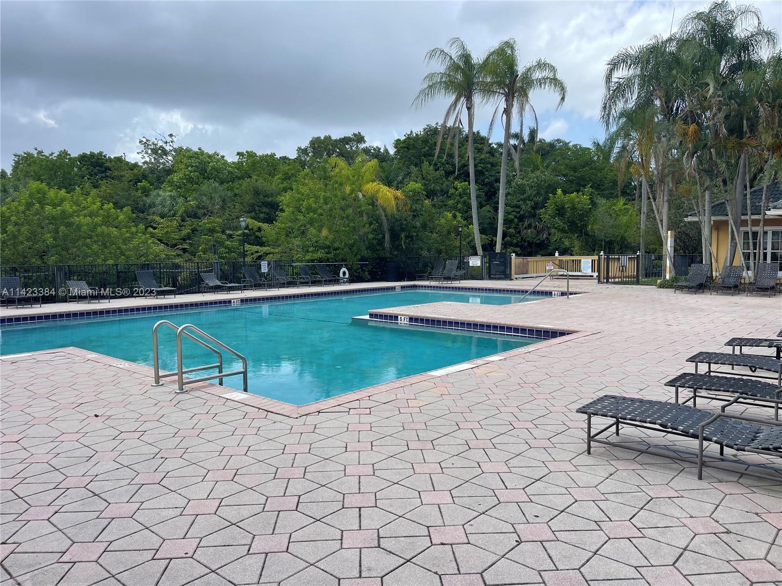 4045 West McNab Road, Unit G106 Pompano Beach, FL 33069 - Photo 21 of 23 a view of a swimming pool and lounge chair