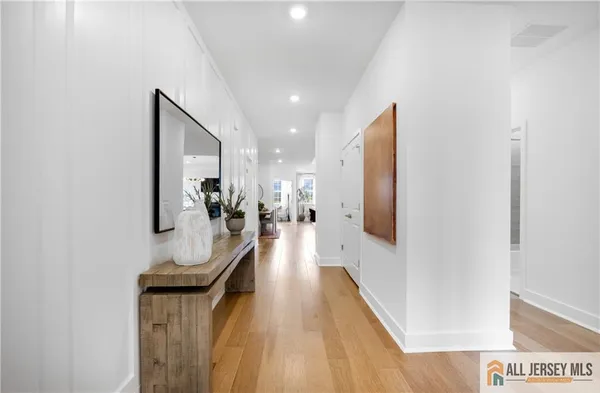 a hallway with mirror and furniture