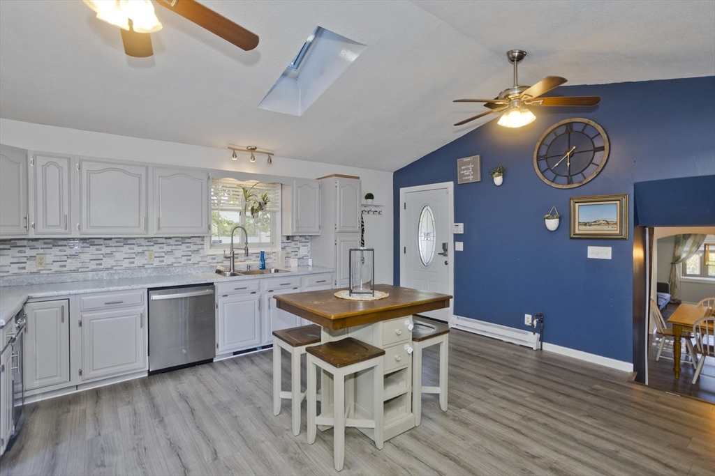 3 Fontaine Street Ludlow, MA 01056 - Photo 6 of 41 a kitchen with granite countertop a stove a sink dishwasher a dining table and chairs with wooden floor