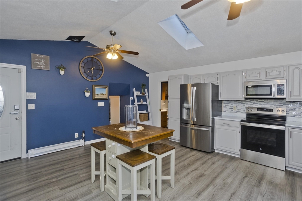 3 Fontaine Street Ludlow, MA 01056 - Photo 7 of 41 a kitchen with stainless steel appliances a stove a refrigerator and a refrigerator with wooden floor
