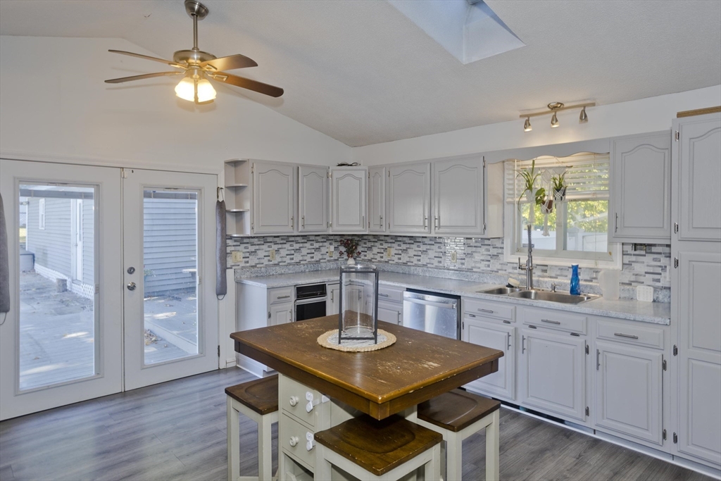 3 Fontaine Street Ludlow, MA 01056 - Photo 10 of 41 a kitchen with a stove a sink dishwasher a dining table and chairs with wooden floor