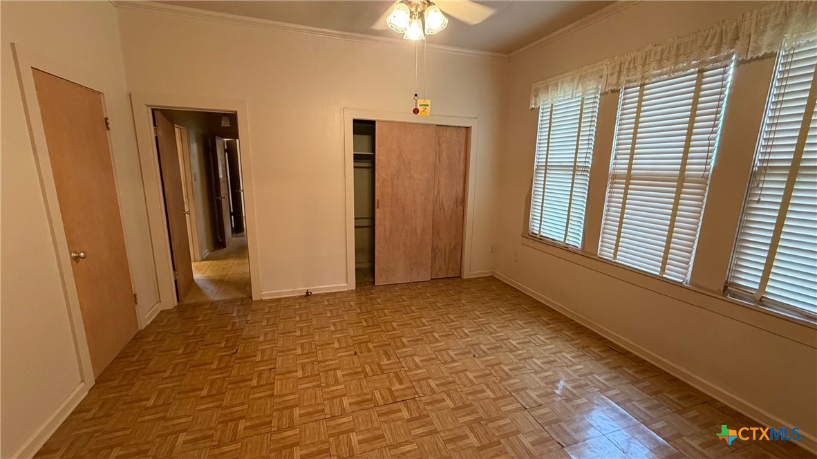 701 East 10th Street Cameron, TX 76520 - Photo 8 of 19 a view of an empty room with window and chandelier fan