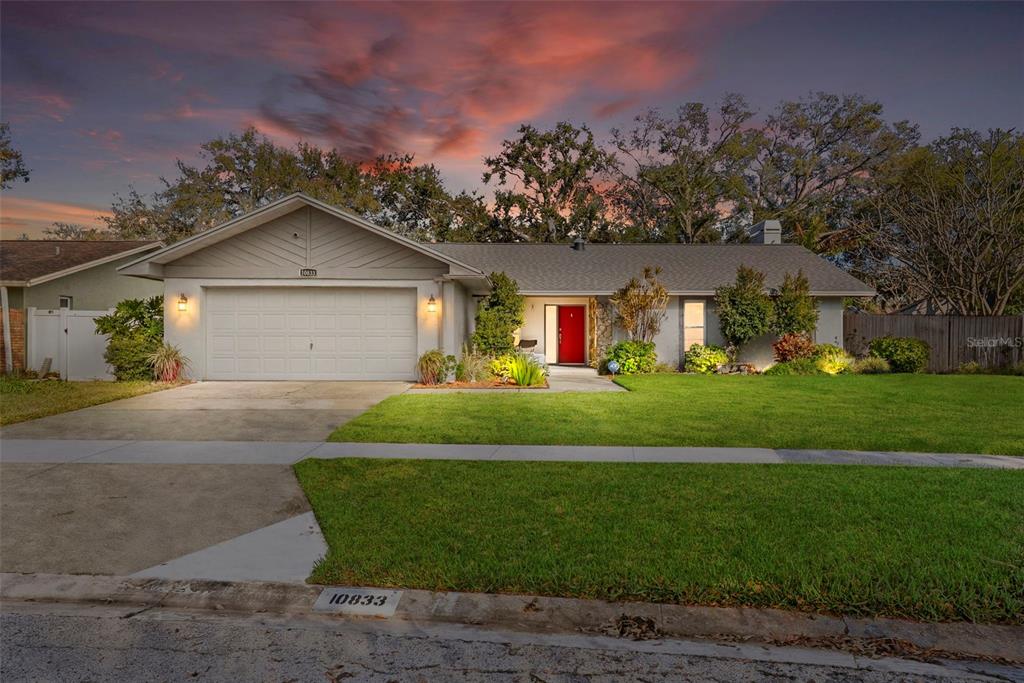 10833 97th Street Largo, FL 33773 - Photo 1 of 1 a front view of a house with a garden and yard