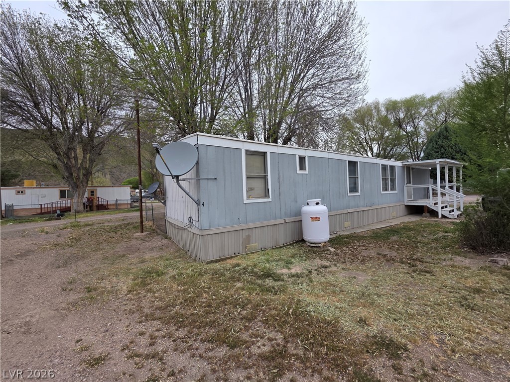 101 Ada Street, Unit 12 Caliente, NV 89008 - Photo 11 of 14 A well-maintained single-wide manufactured home with a covered front porch and expansive yard.