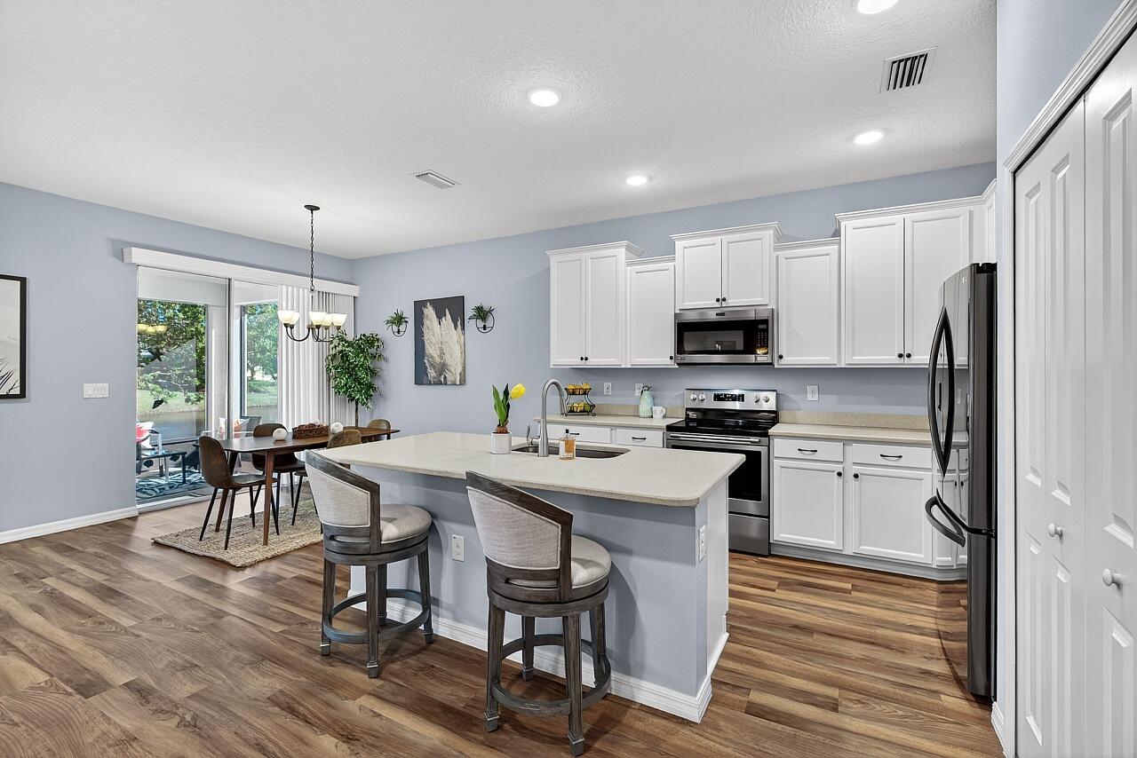 313 Sandcrest Circle Sebastian, FL 32958 - Photo 15 of 42 a kitchen with refrigerator a sink and chairs