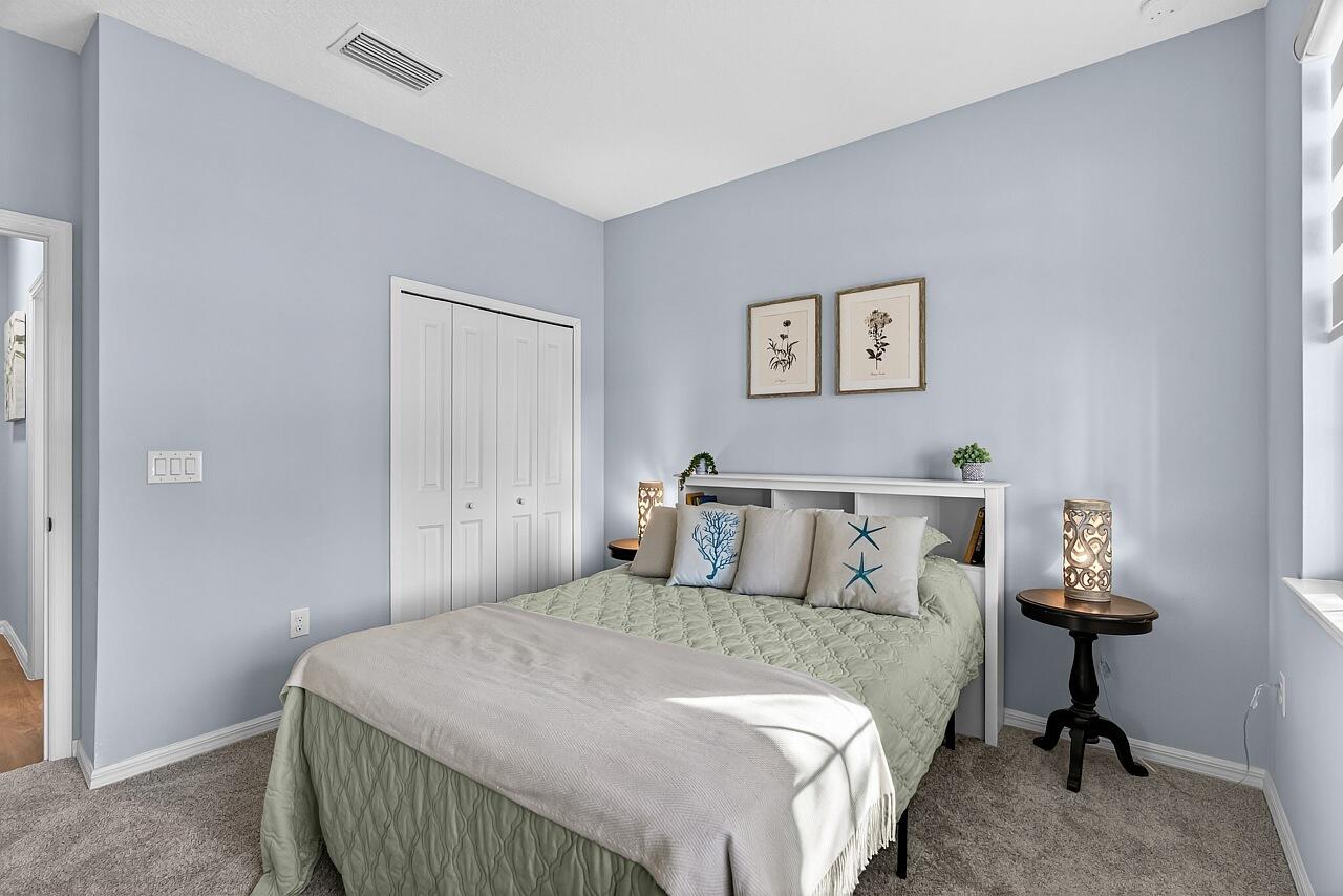 313 Sandcrest Circle Sebastian, FL 32958 - Photo 28 of 42 a bedroom with a bed and a lamp on table