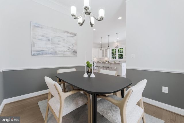 a view of a dining room with furniture and a chandelier fan