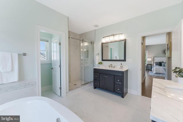 a spacious bathroom with a tub sink and mirror