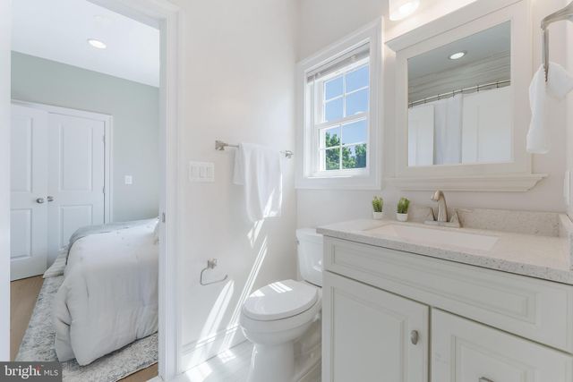 a bathroom with a sink a toilet and a mirror