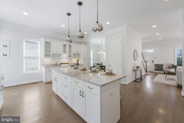 a large white kitchen with lots of counter space sink and a refrigerator