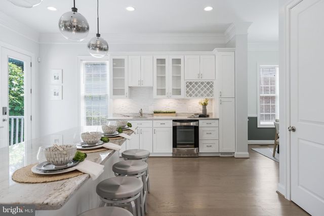 a kitchen with stainless steel appliances kitchen island granite countertop a stove and white cabinets
