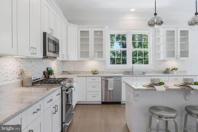 a kitchen with granite countertop a sink stainless steel appliances and cabinets