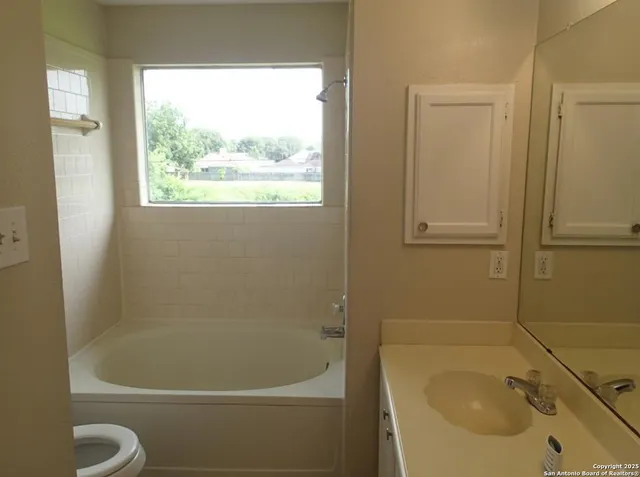 a white bath tub sitting next to a white sink and a toilet