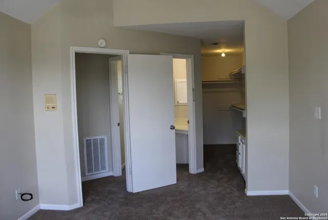 a view of a hallway with closet and a bathroom