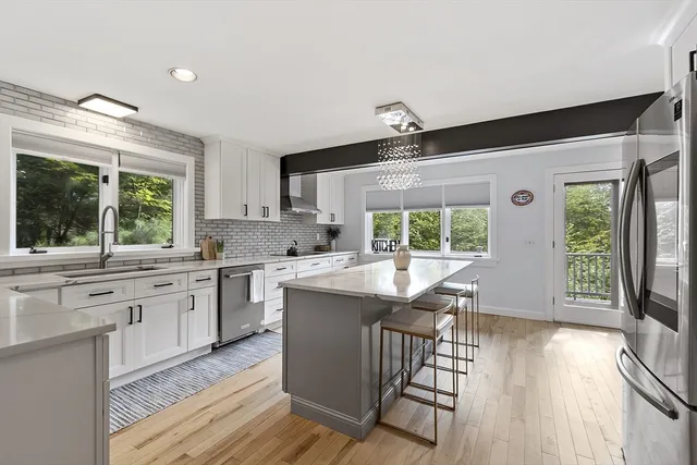 a kitchen with white cabinets and a large window