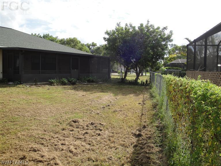 8395 Lemon Road Fort Myers, FL 33967 - Photo 3 of 4 a view of a backyard with large trees and wooden fence