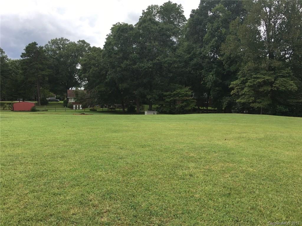 a view of a green field with trees in the background