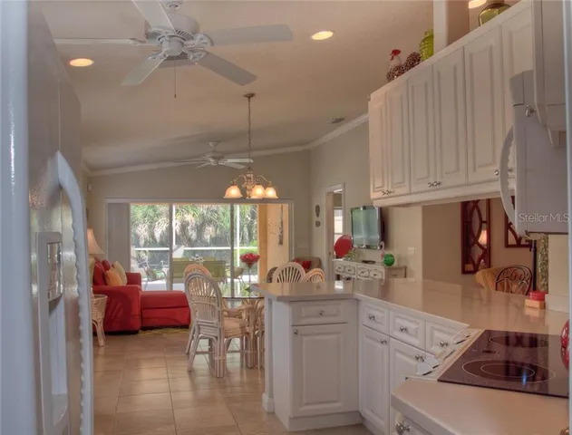 a kitchen with stainless steel appliances kitchen island granite countertop a sink dishwasher a dining table and chairs with wooden floor