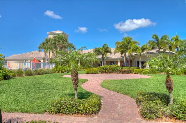a front view of a house with a yard and potted plants