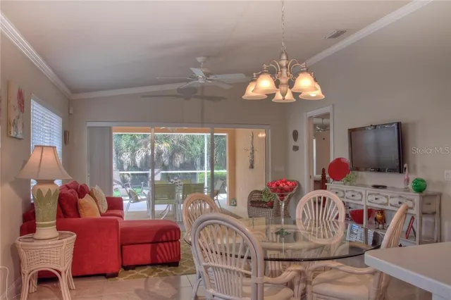 a dining room with furniture a chandelier and a flat screen tv
