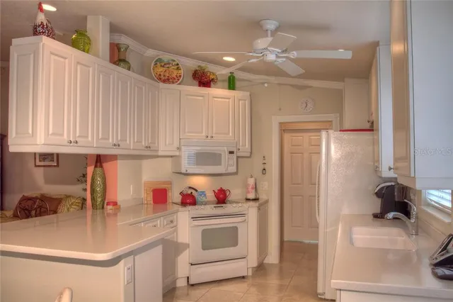 a kitchen with white cabinets and sink