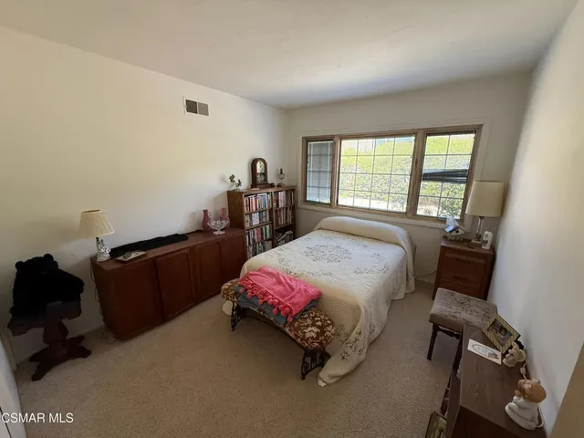 a bed room with a bed window and a chair