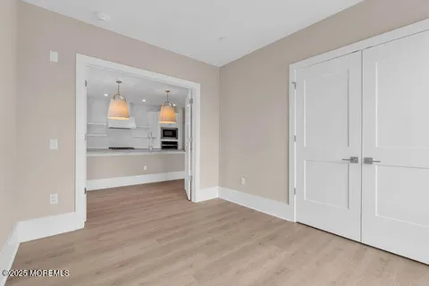 a view of a hallway and wooden floor a kitchen