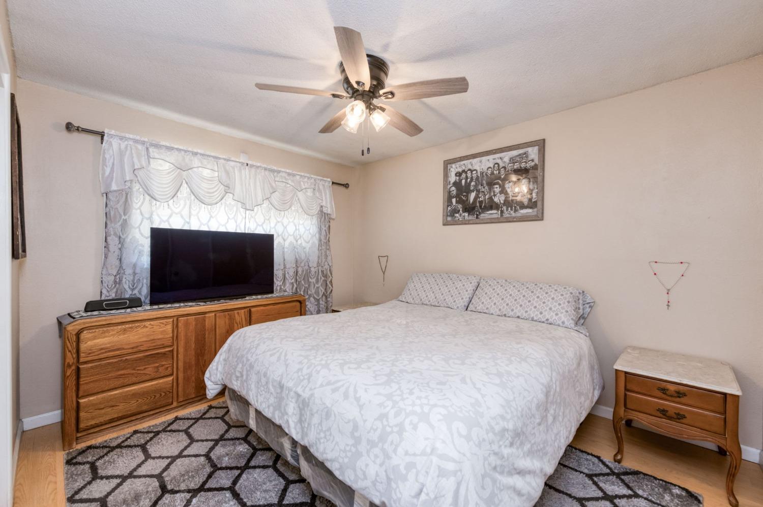 1325 Terry Avenue Clovis, CA 93612 - Photo 12 of 28 a bedroom with a bed and a flat screen tv