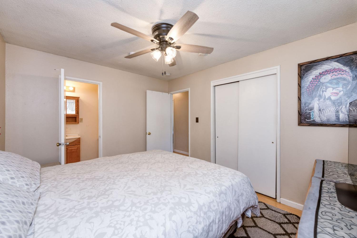 1325 Terry Avenue Clovis, CA 93612 - Photo 20 of 28 a bedroom with a large bed and a chandelier