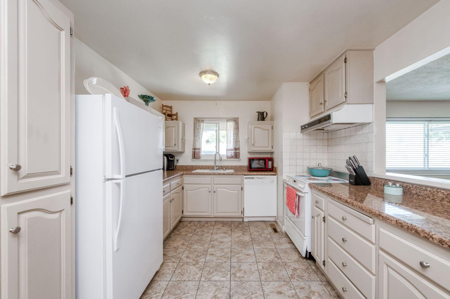 1325 Terry Avenue Clovis, CA 93612 - Photo 10 of 28 a kitchen with white cabinets and white appliances