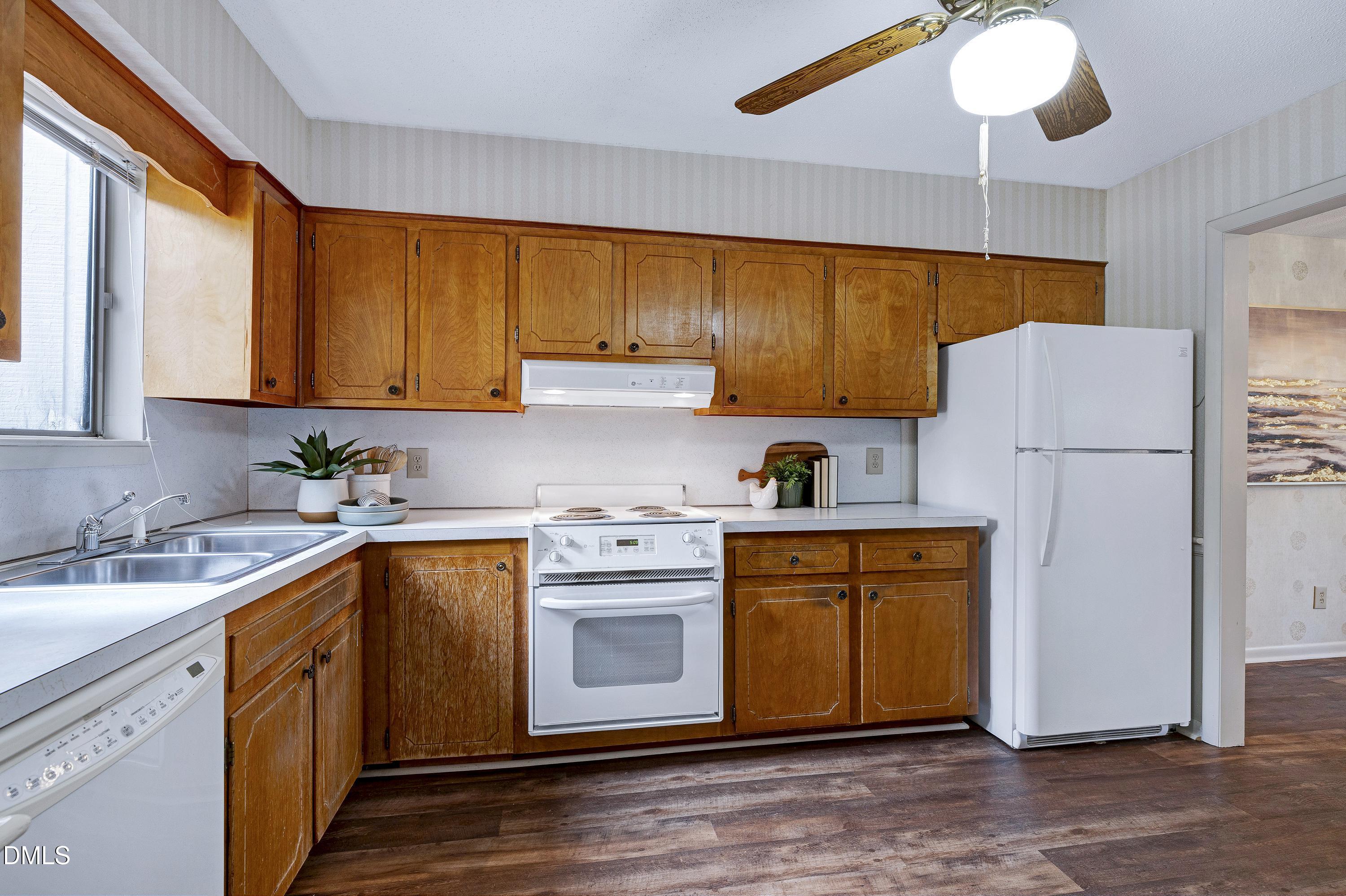 3905 Wendy Lane Raleigh, NC 27606 - Photo 15 of 42 a kitchen with a sink a refrigerator a microwave and cabinets