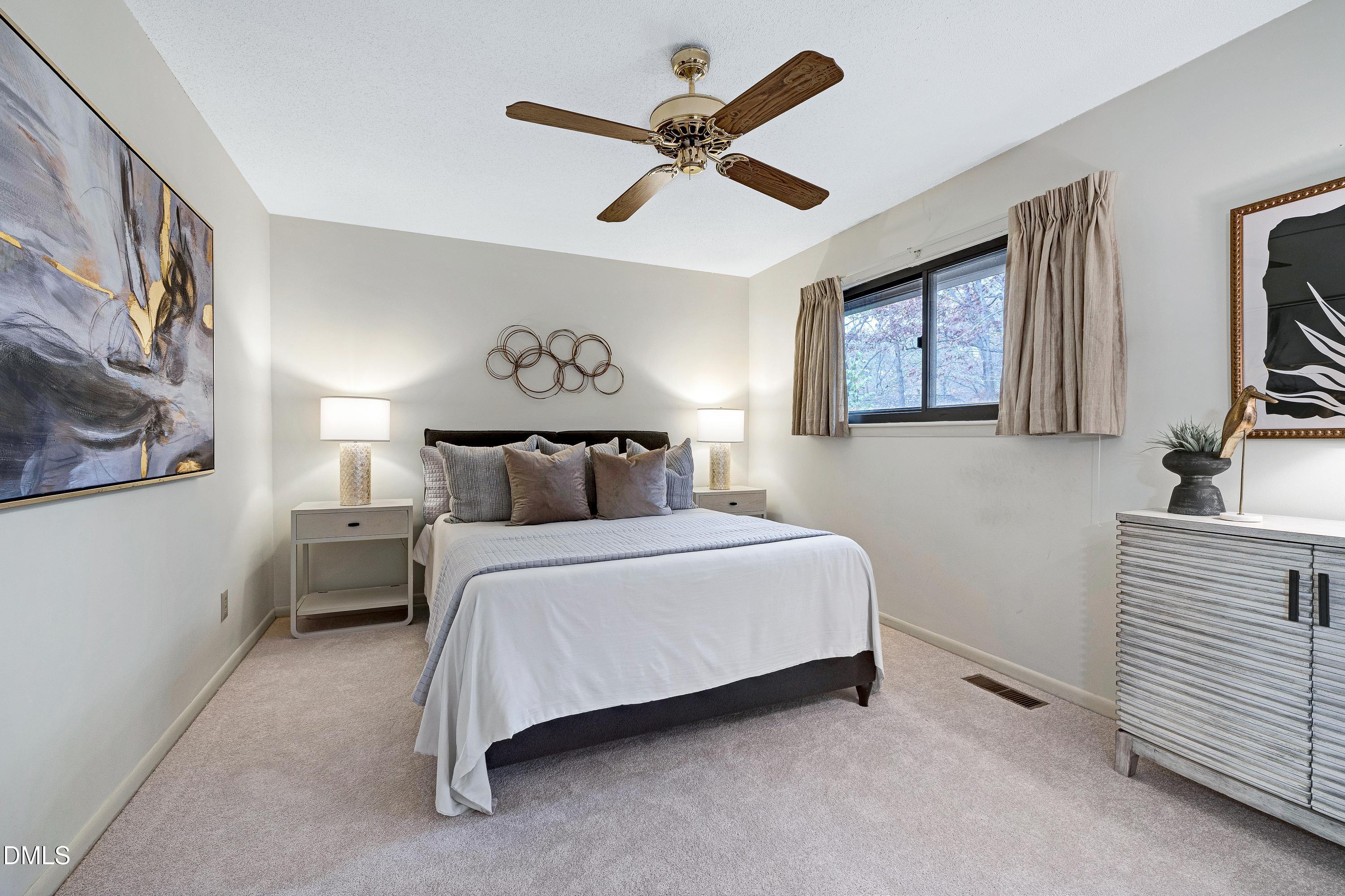 3905 Wendy Lane Raleigh, NC 27606 - Photo 23 of 42 a spacious bedroom with a bed and a chandelier
