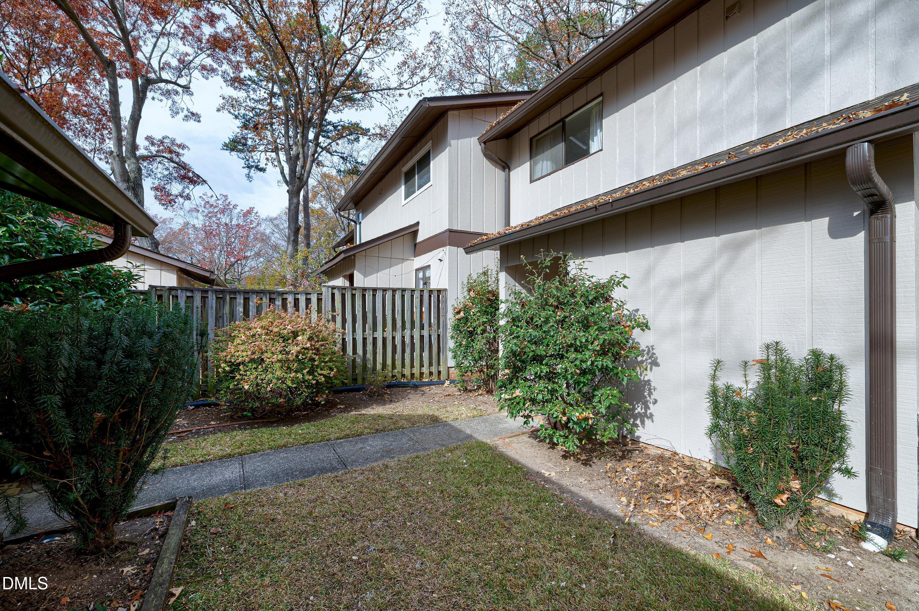 3905 Wendy Lane Raleigh, NC 27606 - Photo 36 of 42 a view of a small yard with plants and wooden fence