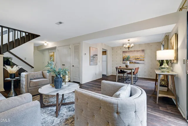 a living room with furniture and hard wood flooring