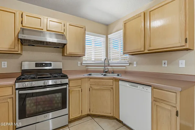 a kitchen with cabinets stainless steel appliances and a sink