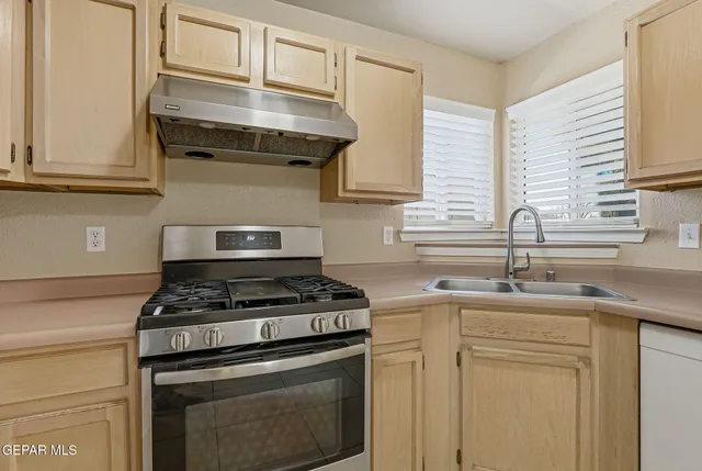 a kitchen with stainless steel appliances granite countertop a sink stove and cabinets