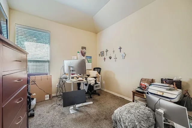 a view of a workspace with furniture and a window
