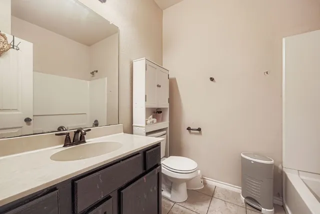 a bathroom with a sink a toilet and a large mirror