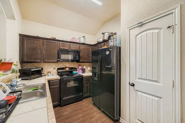 a kitchen with stainless steel appliances granite countertop a refrigerator and a stove top oven