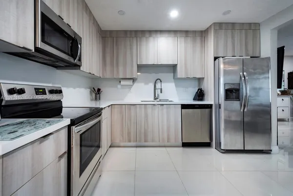 a kitchen with stainless steel appliances a stove sink microwave and cabinets