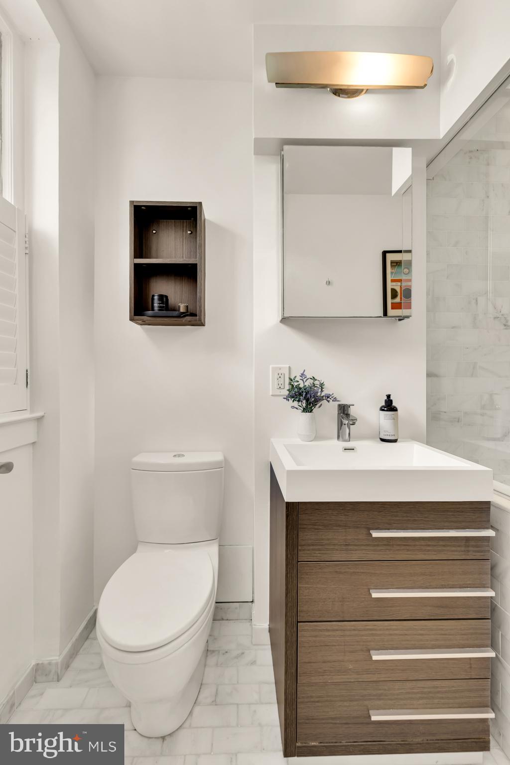1910 Kalorama Road Northwest, Unit 302 Washington, DC 20009 - Photo 19 of 28 a bathroom with a toilet a sink and mirror